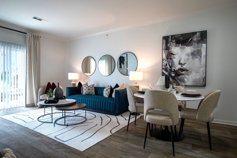 A living room with a blue couch and a white table.