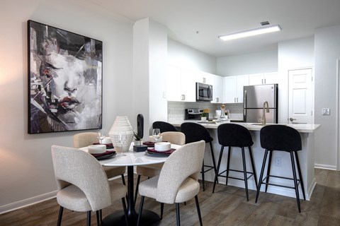 A modern kitchen with a dining table set for four.