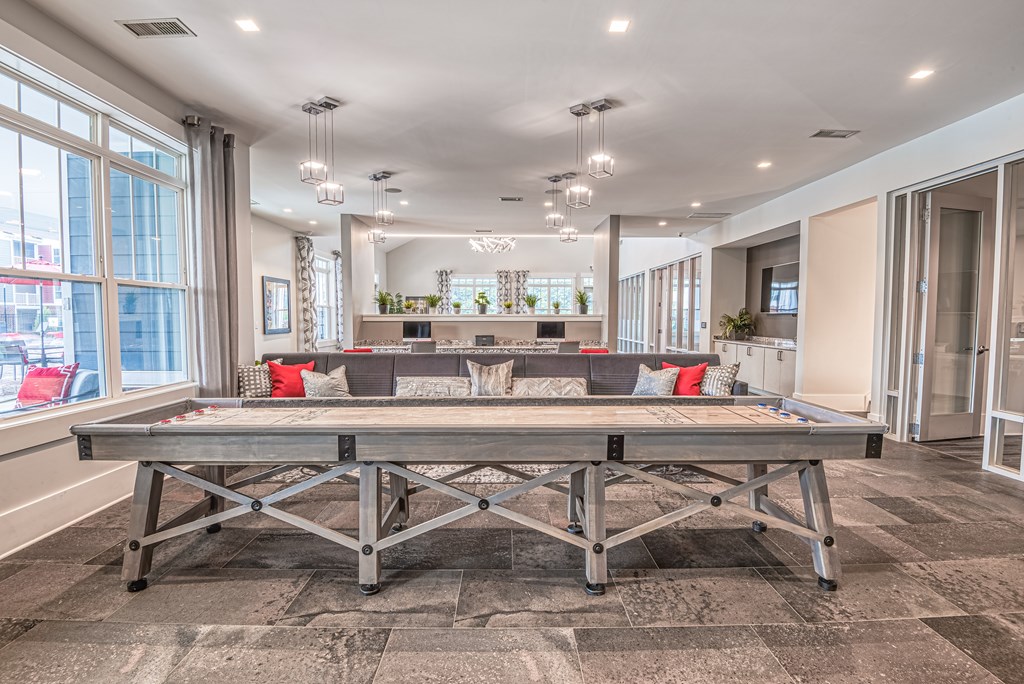 A large table with a metal frame is in the middle of a room with a checkered floor.