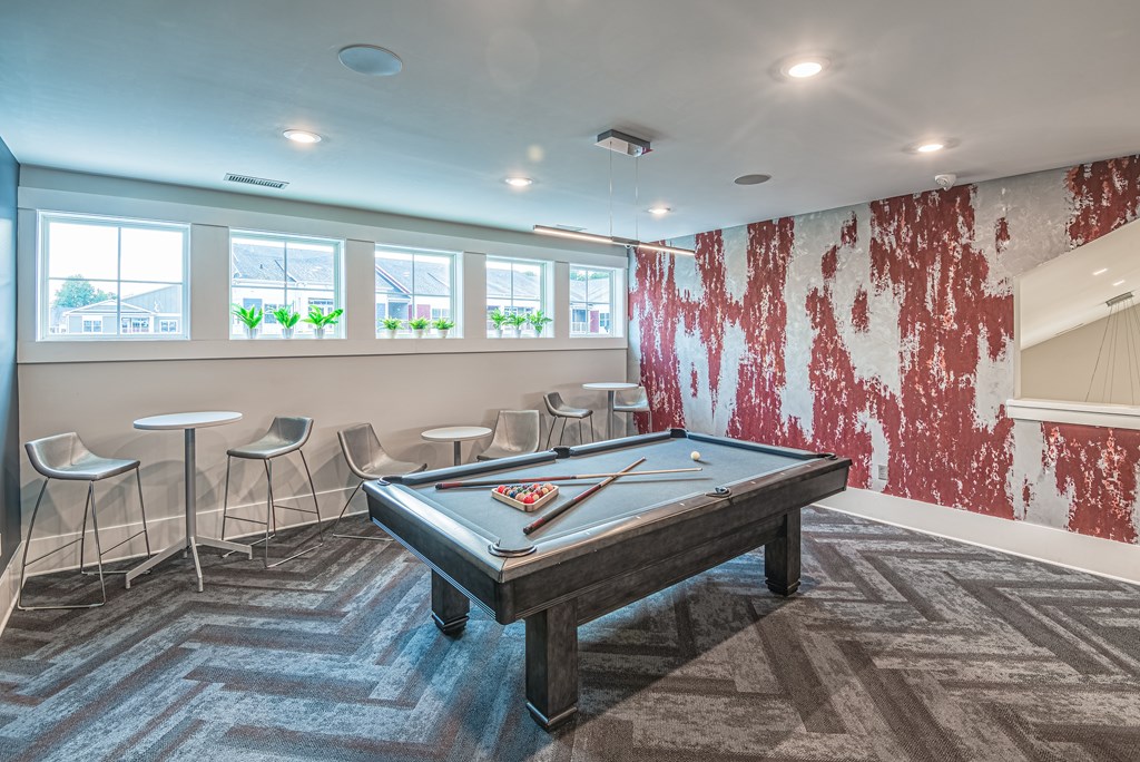 A pool table in a room with a red and white wallpaper.