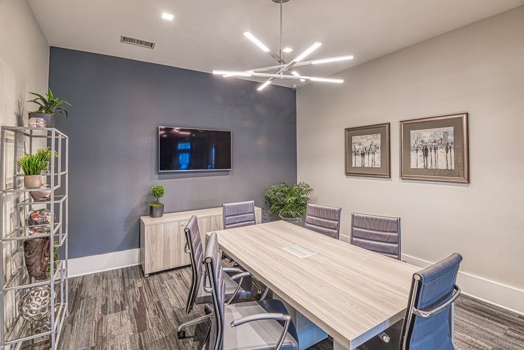 A conference room with a long table and chairs.