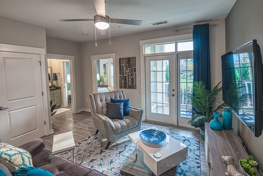 A living room with a grey couch, a blue chair, and a television.
