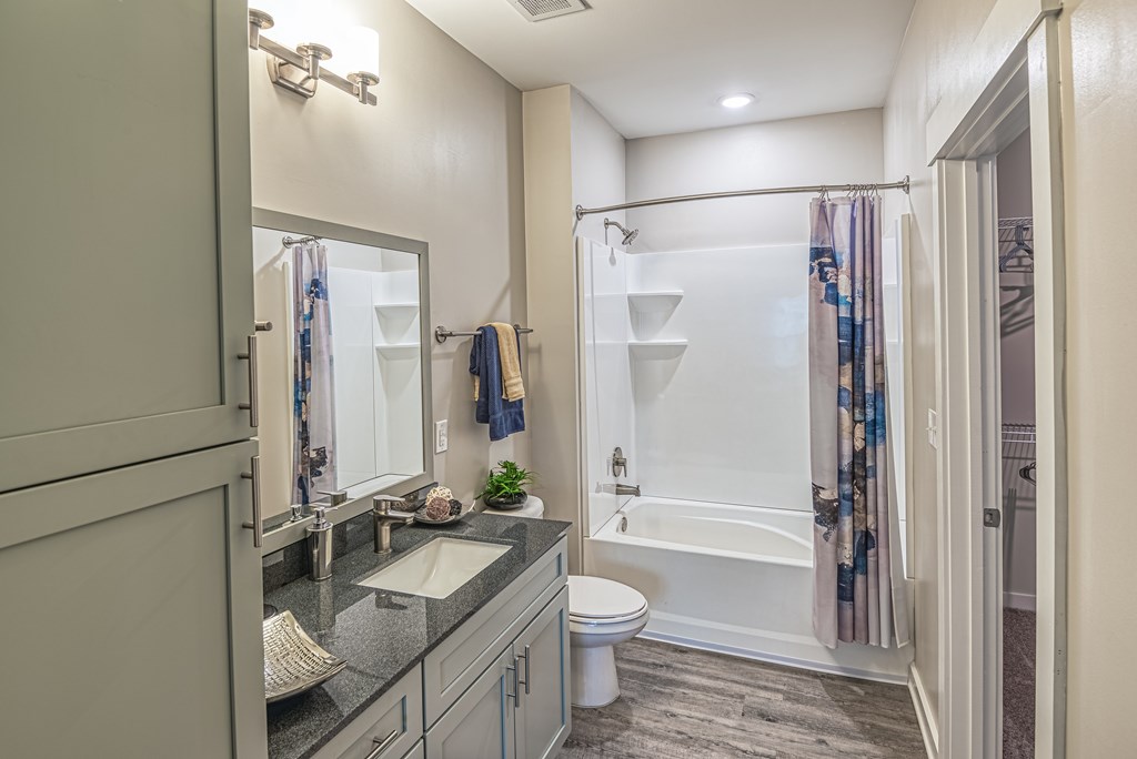 A bathroom with a sink, toilet, and shower.