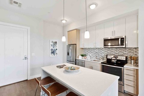 A kitchen with a white table and a white fridge.