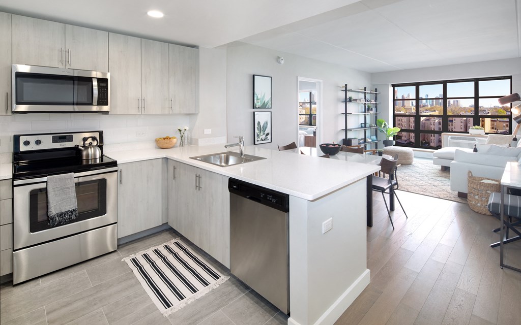 Revetment house modern and spacious kitchen with island and light gray cabinetry.  Stainless steel electric stove top.