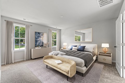 a master bedroom with a bed and two windows