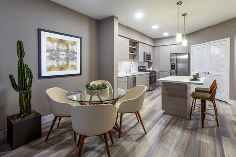 A modern dining room with a glass table and chairs.