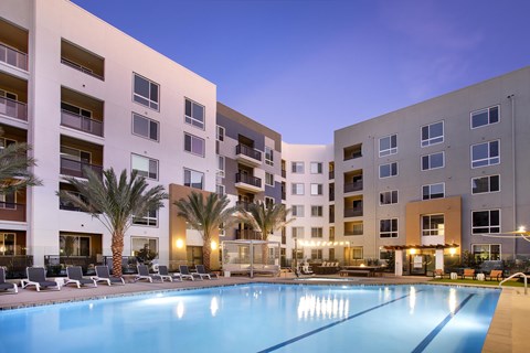 A swimming pool in front of apartment buildings.
