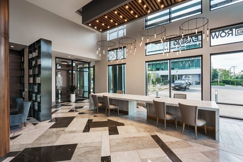 the lobby of a hotel with a large table and chairs