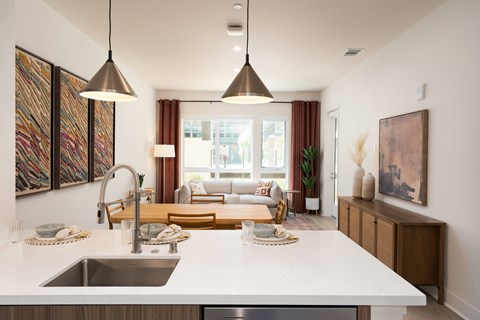 an open kitchen and living room with a white counter top