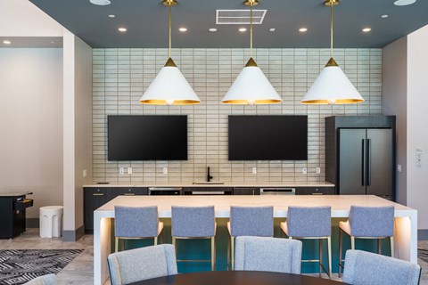 a conference room with a table and chairs and televisions on the wall