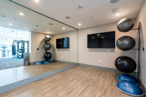a workout room with mirrors and a tv in the corner of a building