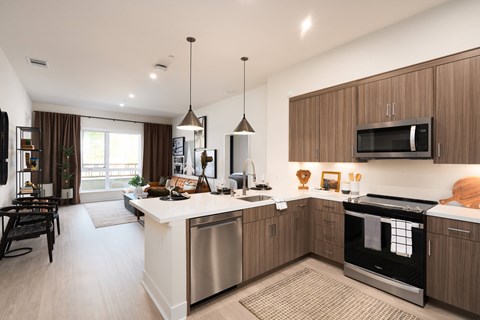 an open kitchen and living room with a large island and stainless steel appliances