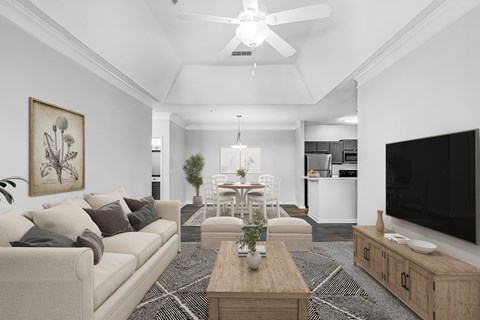 A living room with a beige couch, a wooden coffee table, and a flat-screen TV.