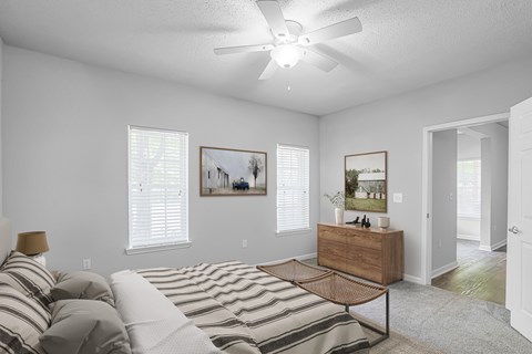 A bedroom with a bed, a dresser, and two pictures on the wall.