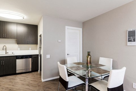 a dining room with a glass table and white chairs