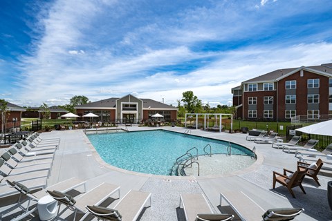 A large outdoor swimming pool surrounded by sun loungers.