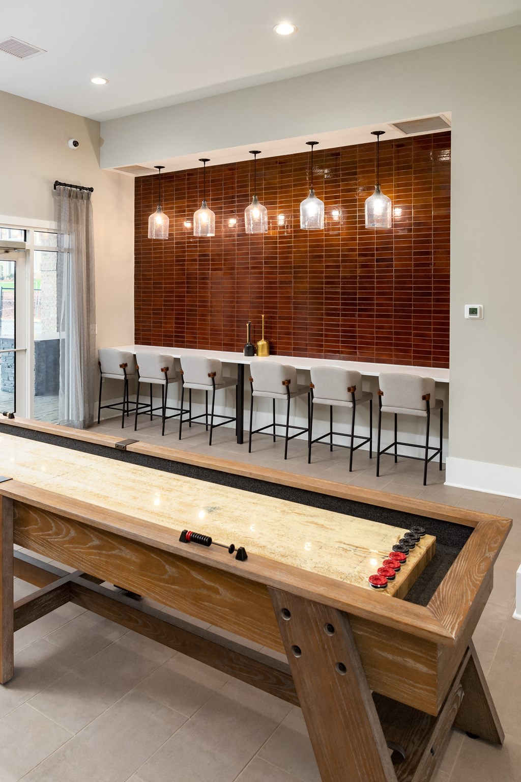a shuffleboard table with a bar in the background