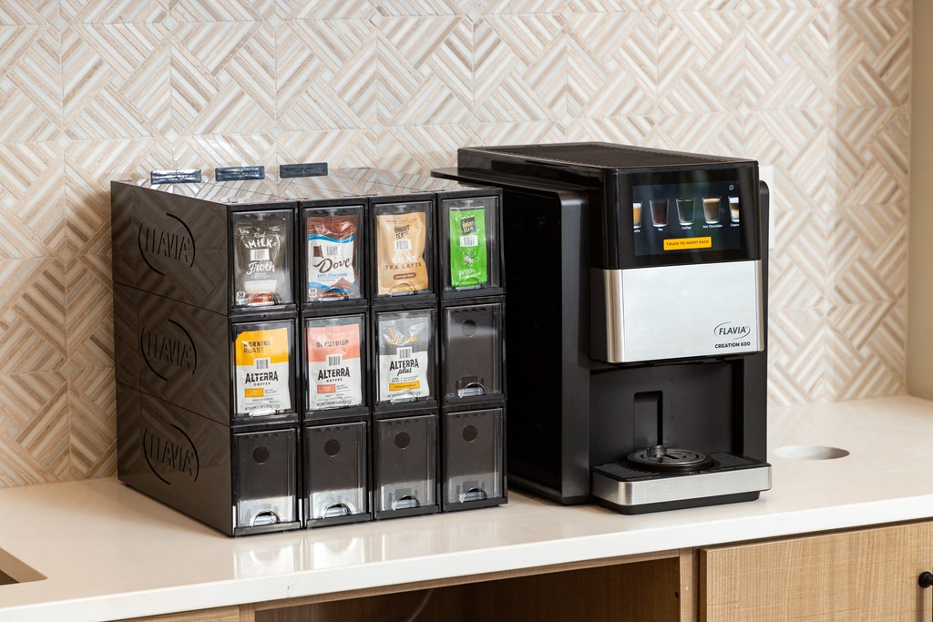 a coffee machine on a counter next to a tray of coffee