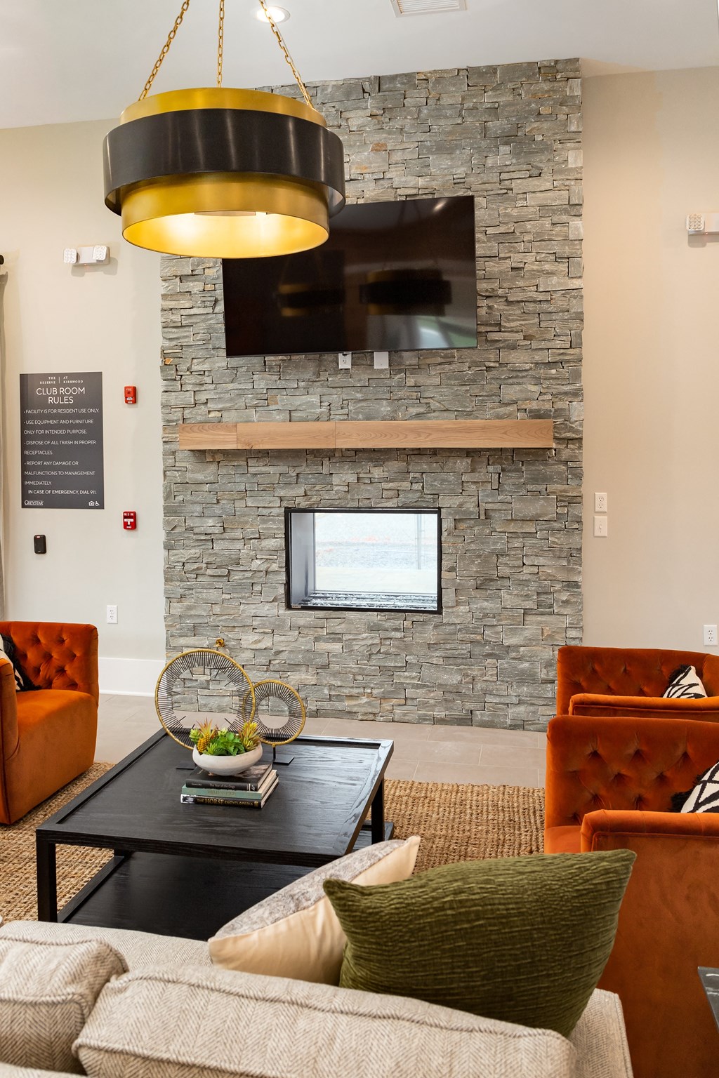 a living room with a couch and a coffee table in front of a fireplace with a tv