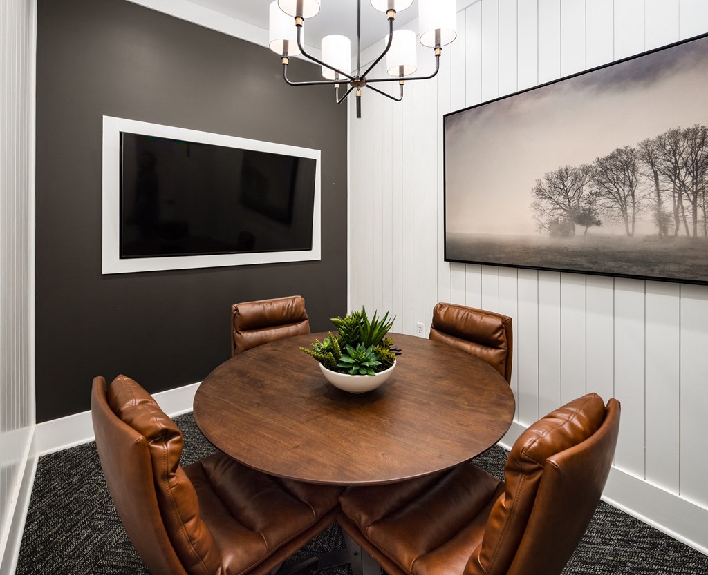 a conference room with a table and chairs and a television on the wall