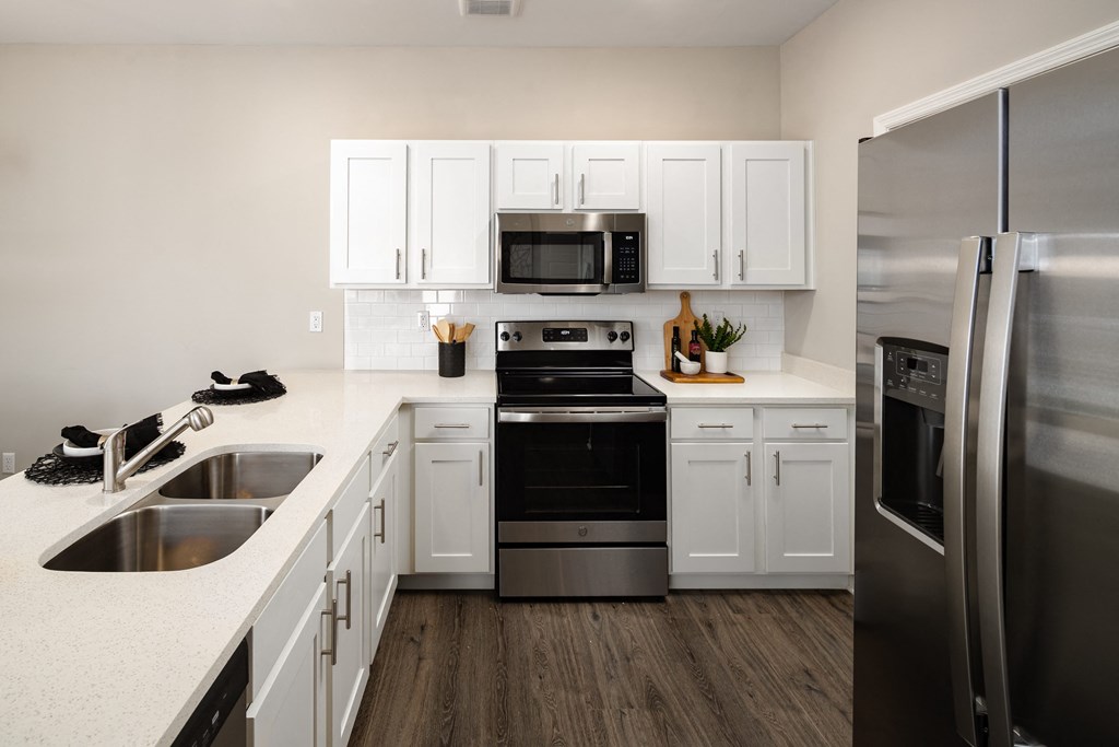 a kitchen with white cabinets and stainless steel appliances