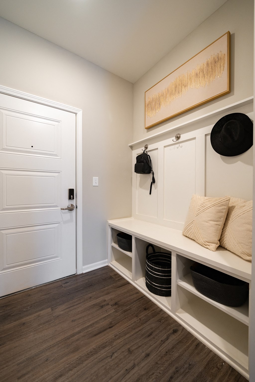 a room with a white door and a white shelf with white shelves and pillows