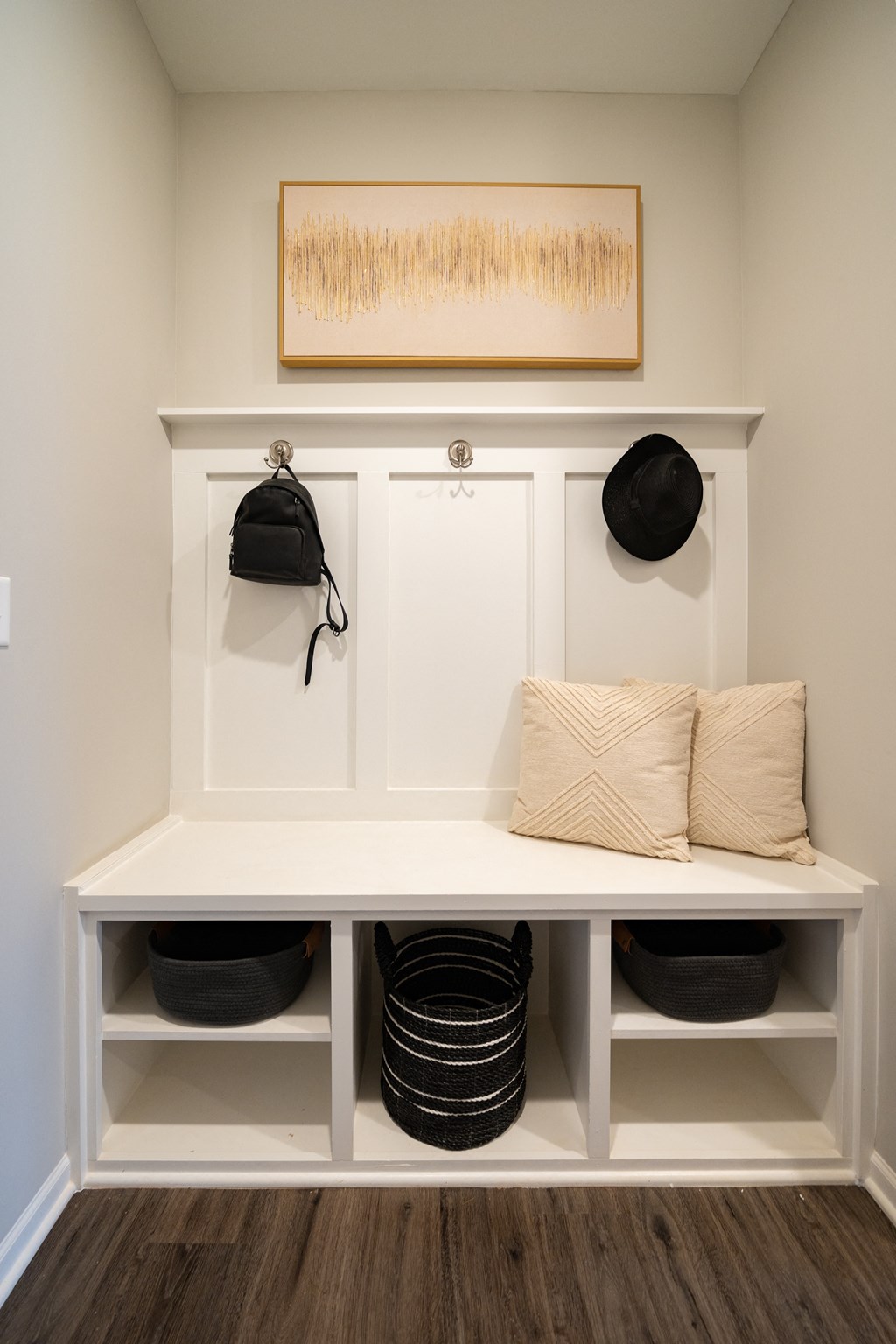 a built in bench with baskets and hats on it