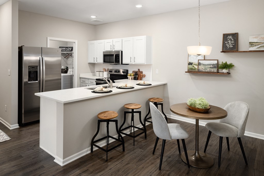 a kitchen with a large island with a breakfast bar and three stools