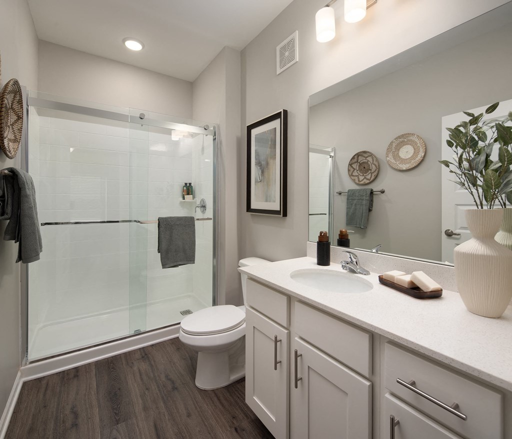 a bathroom with a large mirror and a toilet next to a shower