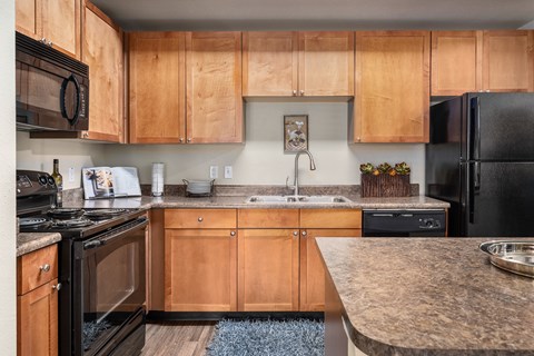 A kitchen with wooden cabinets and black appliances.