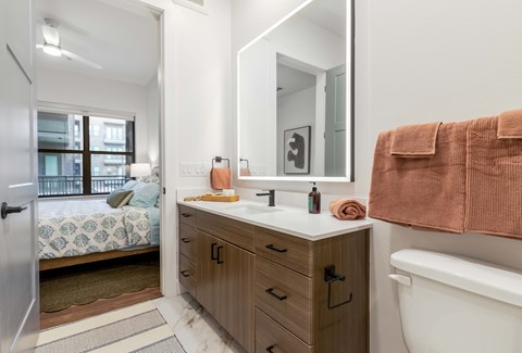 A bathroom with a white sink and a brown towel.