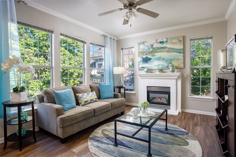 A living room with a couch, a fireplace, and a painting on the wall.