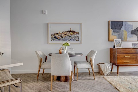 a dining room with a table and chairs and white walls