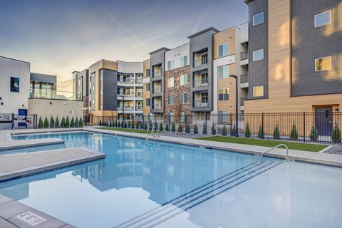 a swimming pool with an apartment building in the background
