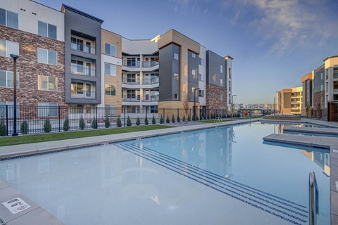 a swimming pool with an apartment building in the background
