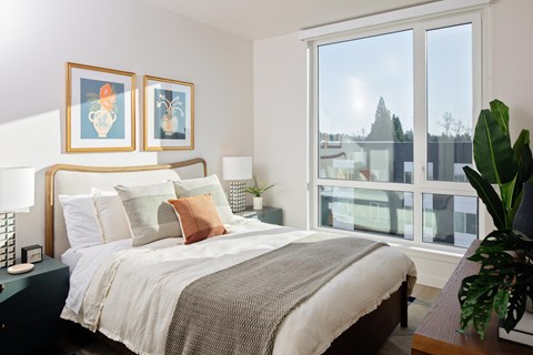 A bedroom with a large bed and two framed pictures on the wall.