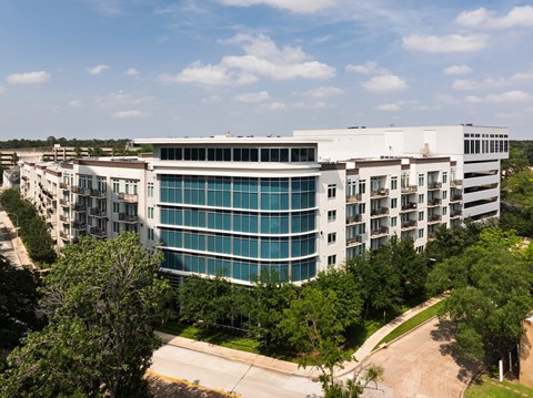A large white building with a curved glass wall in the middle.