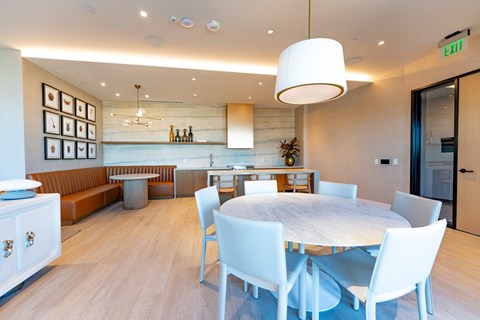 A modern dining room with a round table and white chairs.