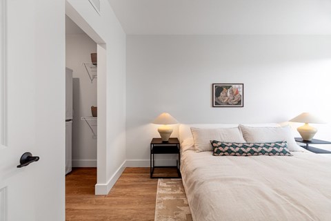 A bedroom with a bed, nightstand, and lamp.