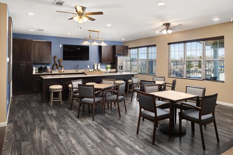 a clubhouse with a kitchen and dining area with tables and chairs