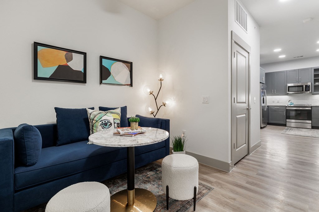 a living room with a blue couch and a round table