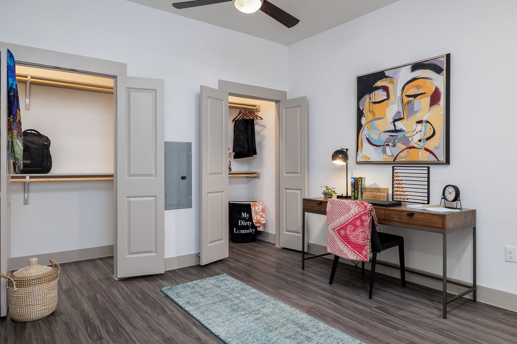 a bedroom with a desk and a closet and a mirror