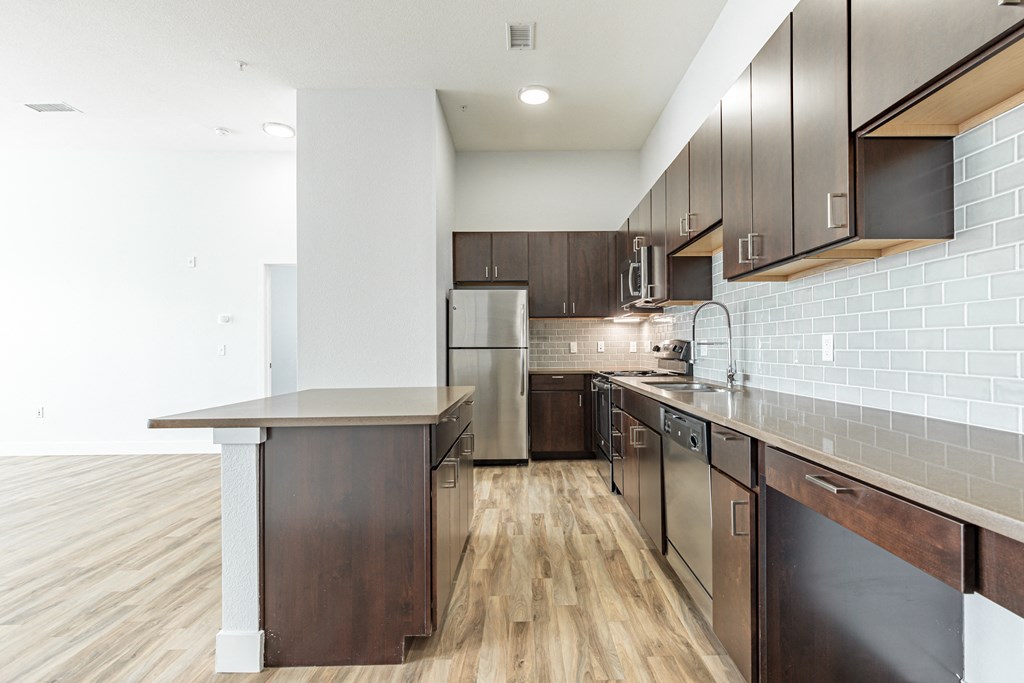 a kitchen with dark wood cabinets and stainless steel appliances