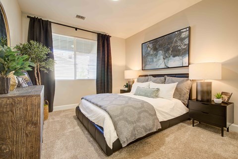 A bedroom with a large bed and a painting above it.