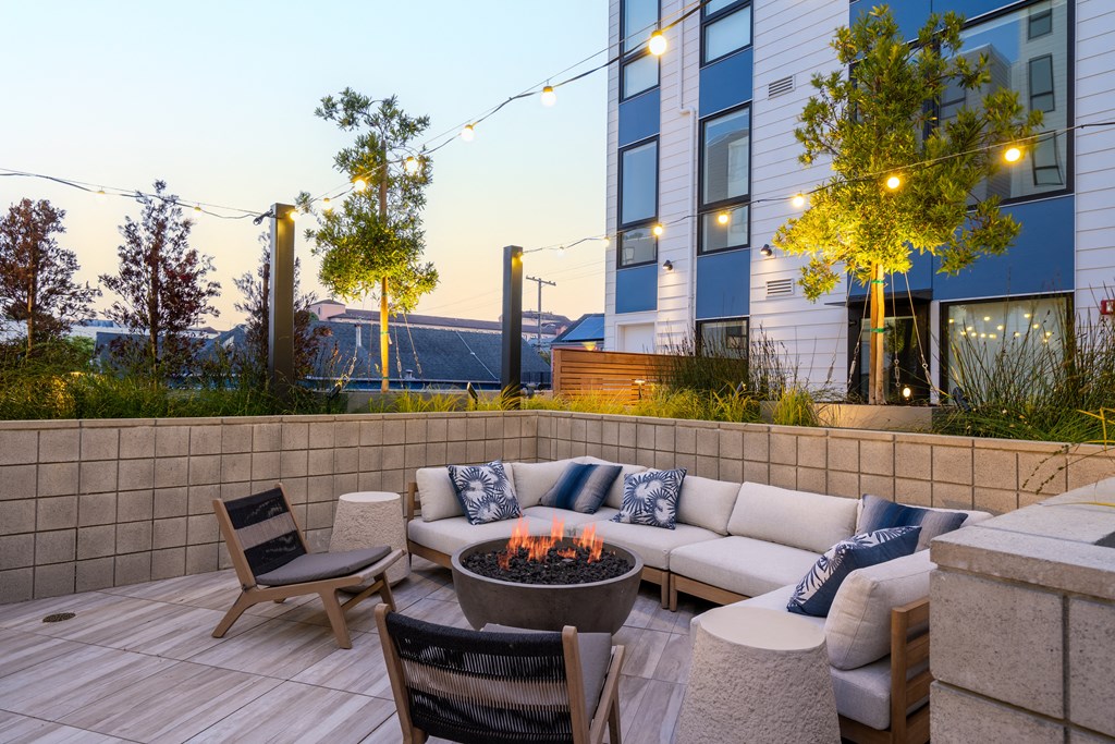 a patio with a fire pit and seating area