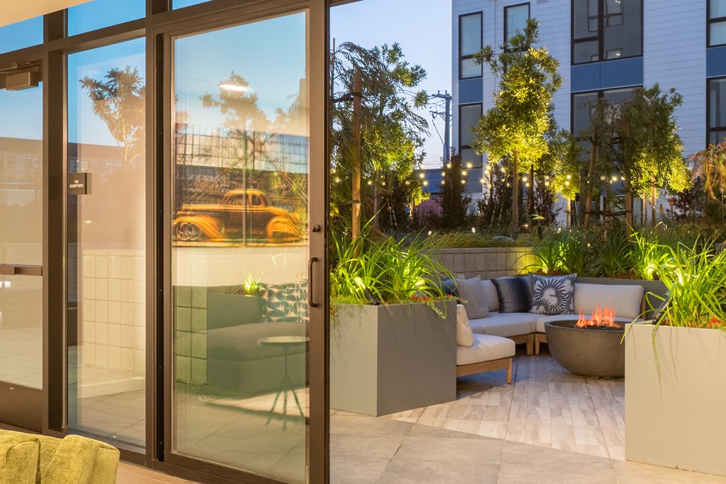 a patio with couches and a fire pit in front of a building