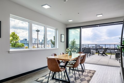 A dining room with a table and chairs and a view of the city.