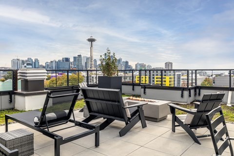 A patio with chairs and a table overlooking a city skyline.