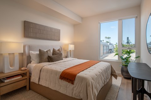 A bedroom with a large bed and a view of the city.